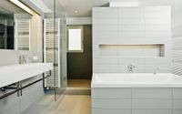 Helles modernes Bad mit großen weißen Fliesen und Badkeramik. Dusche mit Glastür, moderne, schöne Armaturen